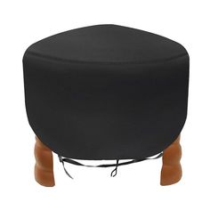 a black ottoman sitting on top of a wooden stool