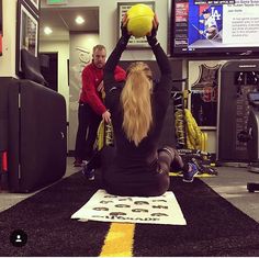 a man and woman are playing with a ball in the middle of an exercise room