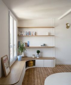 an empty room with shelves and plants in the corner