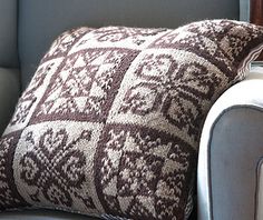 a gray couch with a brown and white pillow sitting on it's backrest