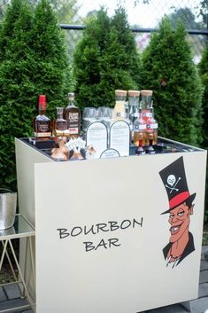 an outdoor bar with liquor bottles on it and a cartoon character painted on the back