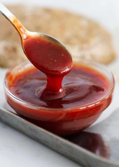 a spoon full of ketchup sitting on top of a plate