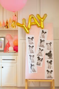 a birthday party with balloons and pictures on the wall, including an air balloon that says yay