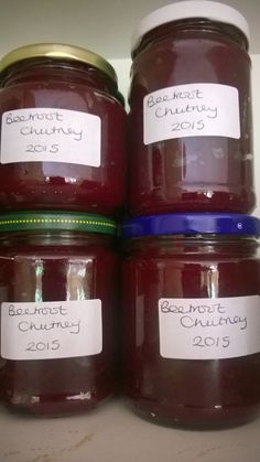 four jars of jam are stacked on top of each other, labeled with the names and date