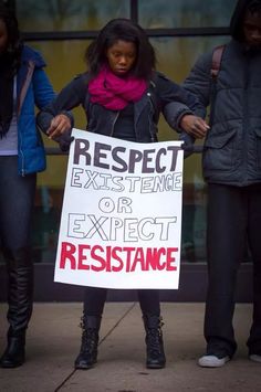 a woman holding a sign that reads respect existence or expect resistance