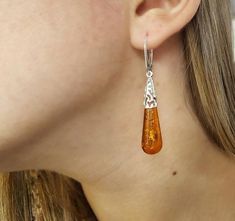 A beautifully crafted unique Baltic Amber pair of earrings. Featuring large teardrop shaped cognac Amber gemstones with a detailed sterling silver frame.Material: Authentic Baltic Amber and 925 sterling silverDimensions: 56 x 10 mm ( 2.20 x 0.39 in )Color: CognacFastening: Lever backFinish: PolishedThe Amber gemstones are a deep and classic cognac hue which shines brightly in natural light. The Amber teardrops are full of natural intricate flakes. The gorgeous open sterling silver work feature o Orange Teardrop Earrings For Formal Occasions, Formal Orange Teardrop Earrings, Brown Teardrop Earrings For Formal Occasions, Elegant Brown Pierced Teardrop Earrings, Elegant Brown Teardrop Earrings For Gift, Formal Brown Teardrop Earrings, Elegant Brown Teardrop Pierced Earrings, Hypoallergenic Amber Teardrop Earrings, Amber Teardrop Earrings