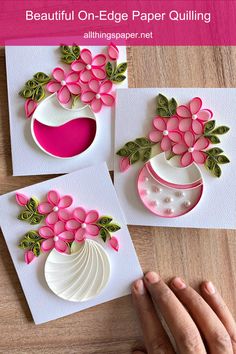 handmade greeting cards with pink flowers and green leaves on white paper are being held by a woman's hands