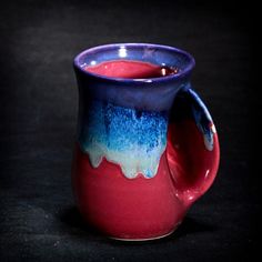 a red and blue mug with some liquid in it