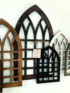 three wooden wall hangings with arched windows and signs attached to the side of them