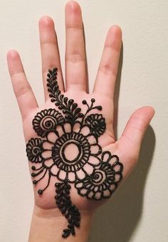 a person's hand with a henna tattoo on it