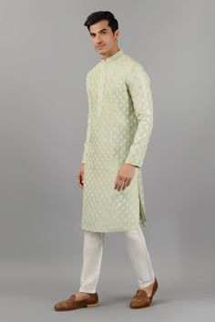 Pistachio green silk kurta with mandarin collar, all over floral butti pattern and thread embroidery. Paired with white straight fit pants.
Components: 2
Pattern: Embroidered
Type Of Work: Thread Work
Neckline: Mandarin Collar
Sleeve Type: Full Sleeves
Fabric: Silk
Color: Green
Other Details: 
Embroidered collar and placket
Side slits on kurta
Kurta Closure: Front button placket
Occasion: Mehendi and Puja,Sangeet - Aza Fashions Green Cotton Silk Sherwani With Zari Work, Pista Green Traditional Wear With Chikankari Embroidery, Pista Green Long Sleeve Traditional Wear With Chikankari Embroidery, Festive Pista Green Long Sleeve Kurta, Festive Long Sleeve Pista Green Kurta, Pista Green Long Sleeve Kurta For Transitional Season, Pista Green Long Sleeve Kurta, Green Cotton Silk Sherwani For Diwali, Spring Pista Green Traditional Wear With Cutdana