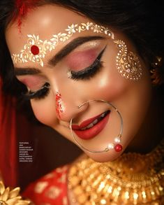 a woman with makeup and jewelry on her face