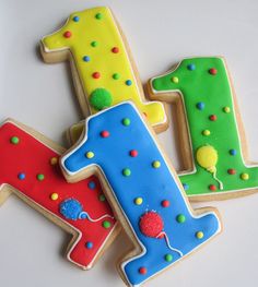 three decorated cookies in the shape of numbers 1, 2, 3 and 4 on a table