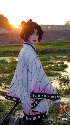 a woman in a kimono is standing by the water