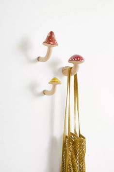 two mushrooms are hanging on the wall next to a purse