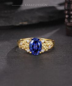 a gold ring with an oval blue stone surrounded by small white and yellow diamond accents