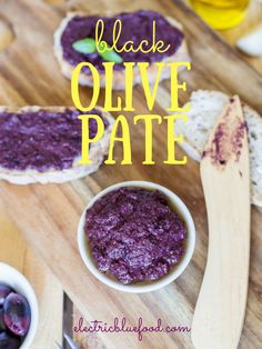 black olive pate in a bowl next to bread on a cutting board with blueberries