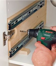 a man is using a drill to attach drawers