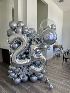 the number 25 is made out of silver balloons