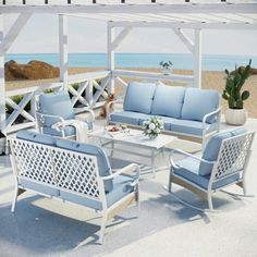 an outdoor living area with white furniture and blue cushions