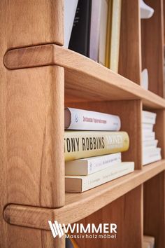 the books are stacked on top of each other in this bookcase, which is made out of wood