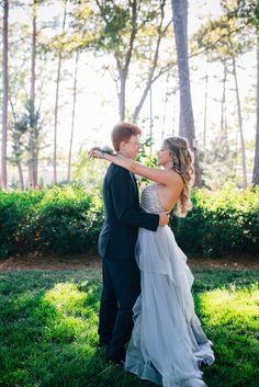 a bride and groom standing in the grass