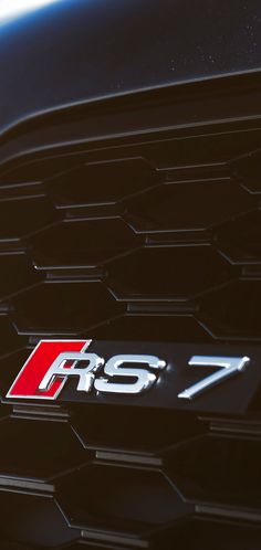 the emblem on the front of a black sports car with red and white letters that read r s7