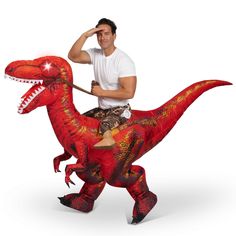 a man riding on the back of a red dinosaur costume