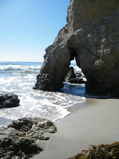 an ocean view with rocks sticking out of the water and waves coming in to shore