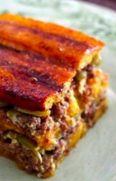 a close up of a plate of food with meat and cheese on it's side