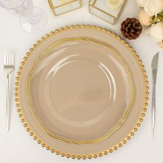 an empty plate on a table with silverware and flowers