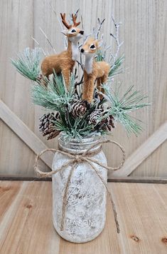 a mason jar filled with pine cones and deer figurines