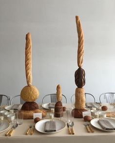 a table topped with bread and buns in the shape of people's heads