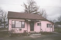 a pink house sitting on the side of a road