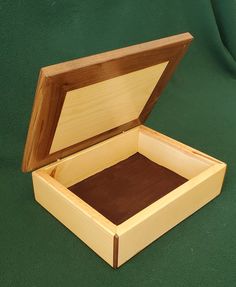 an open wooden box sitting on top of a green surface