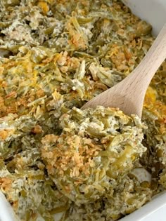 a casserole dish with spinach, cheese and bread crumbs in it