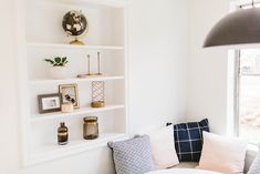 a living room filled with lots of furniture and bookshelves next to a window