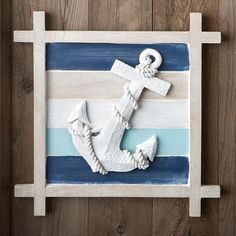 an anchor painted on the side of a wooden wall with blue and white stripes behind it