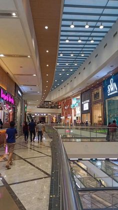 people are walking through the mall with their shopping bags in hand and there is no one on the escalator