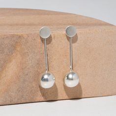 Bold, powerful, and absolutely stunning. Designed to be worn long or as a simple stud, these lightweight earrings are effortless and easily transition from day to night. Ideal for the modern minimalist, the perfect addition to any capsule wardrobe. While our designs are modern, our approach is based in capturing the ancient. We collaborate with master craftspeople to create each piece. Finish: Sterling Silver Stud Diameter: 0.25 inches Earring Drop Length: 1.75 inches Made entirely by hand, slig Chemistry Jewelry, Pendulum Earrings, Body Chemistry, Studded Jacket, Ethical Jewelry, Pop Bottles, Circle Studs, Lightweight Earrings, To Night