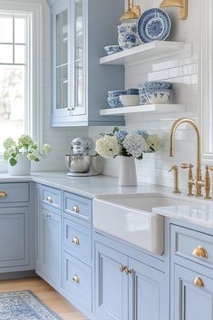 a blue and white kitchen with gold faucets