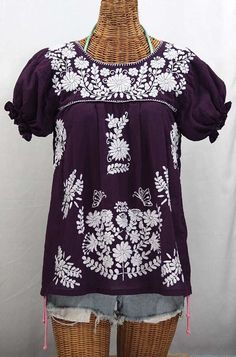 "* Ornate hand embroidery and traditional puff sleeves, available here in PLUM with WHITE embroidery. * Light, gauzy and semi-sheer 100% cotton throughout; wear it billowy and flowing in the traditional bohemian style. * Dyed, distressed and embroidered entirely by hand for an authentic, retro-vintage and hippie casual vibe. * Our ornate butterfly floral embroidery patterns are a faithful tribute to the original Mexican style hippie blouses of the 1970's. * Caringly embroidered by hand, each top Cultural Clothes, Mexican Blouses, Mexican Peasant Blouse, Mexican Clothing, Mexico Fashion, Embroidery Clothes, Embroidered Tops, Hippie Blouse, Mexican Embroidery