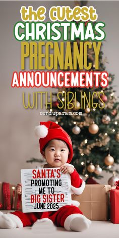 a baby in santa's outfit holding up a sign