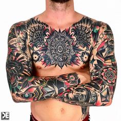 a man with tattoos on his chest and arms is standing in front of the camera