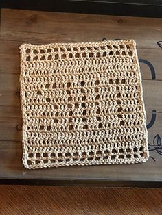 a piece of crochet sitting on top of a wooden table