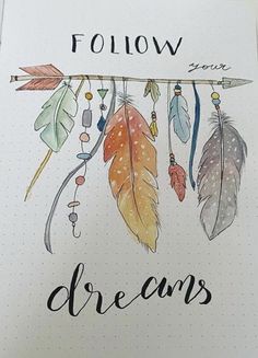 a notebook with some feathers hanging from it's side and the words follow your dreams written