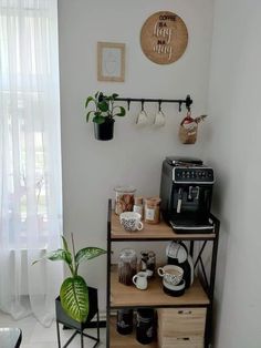 a shelf with coffee cups and mugs on it next to a potted plant