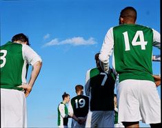 several soccer players in green and white uniforms are standing together with their hands on their hipss