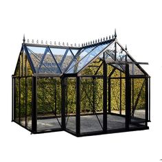 a small black greenhouse with glass roof and side walls in front of bushes on a white background