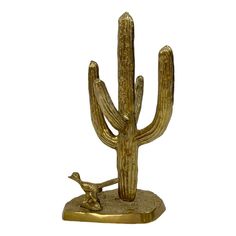 a golden cactus and bird statue on a white background